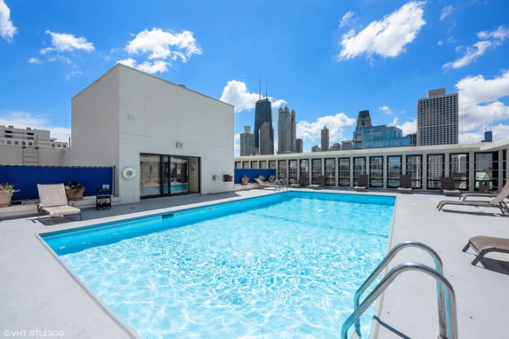 Rooftop swimming pool with surrounding cityscape view.
