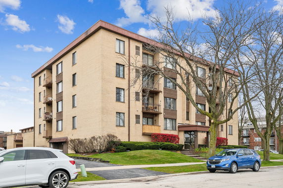 Front view of a multi-story apartment building with balconies.