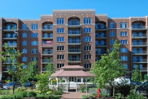 Front view of a multi-story brick apartment building with balconies.