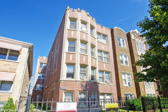 Front view of a multi-story brick apartment building.