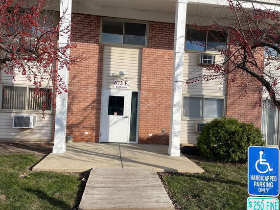 Front view of a building with a brick facade and white columns.