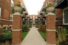 Front view of a multi-story apartment complex with brick exterior and balconies.