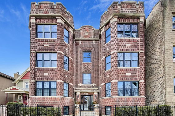 Front view of a multi-story brick building with multiple windows.
