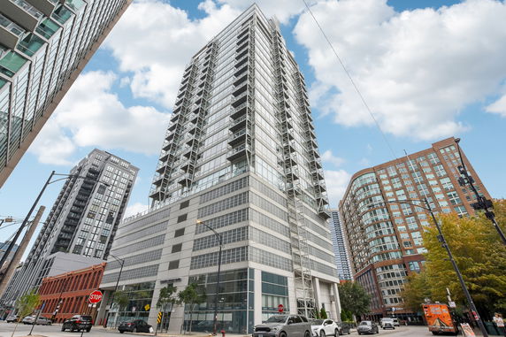 Front view of a modern high-rise building with glass and metal structure.