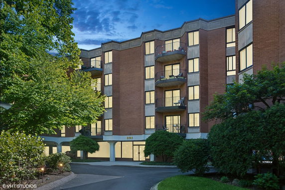 Front view of a multi-story residential building with balconies and large windows.