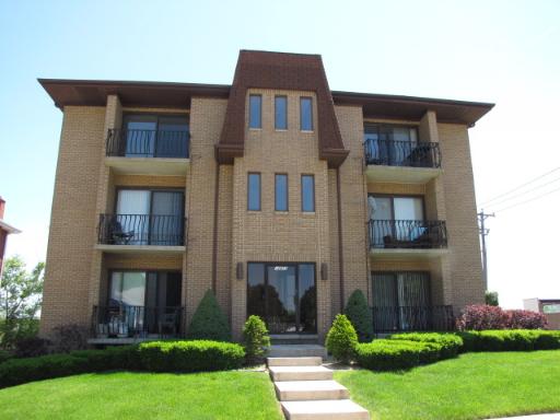 Front view of a three-story apartment building with balconies.