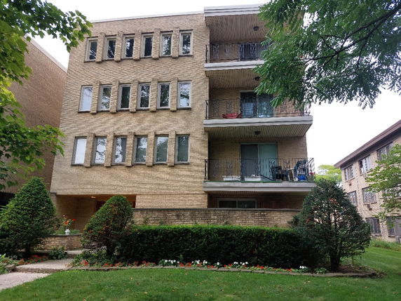 Front view of a multi-story brick building with balconies.