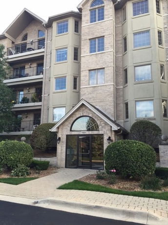 Front view of a multi-story building with a glass entrance and balconies.