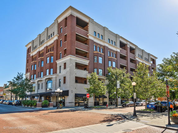 Front view of a multi-story brick building on a city corner.