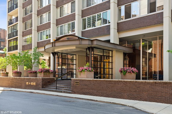Front view of a multi-story building with brick and large windows.
