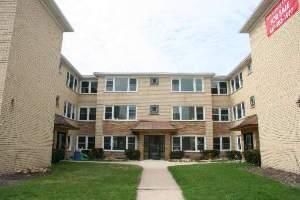 Front view of a three-story apartment building with multiple windows.