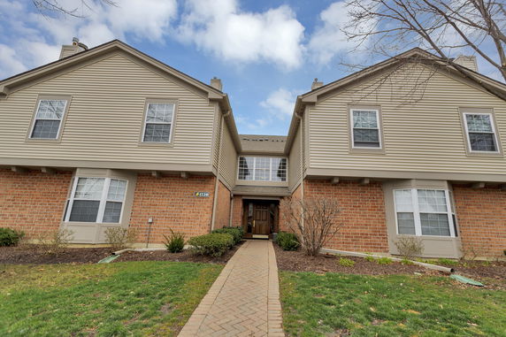 Front view of a multi-story house with brick and siding exterior.