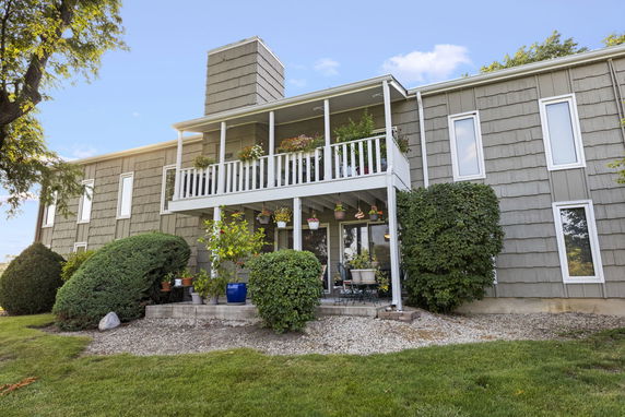 Front view of a two-story house with a balcony and large windows.