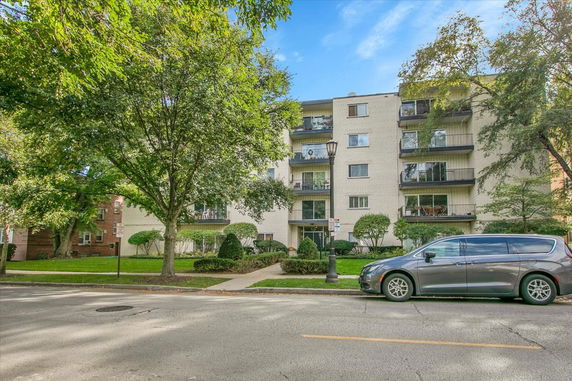 Front view of a multi-story apartment building with balconies.