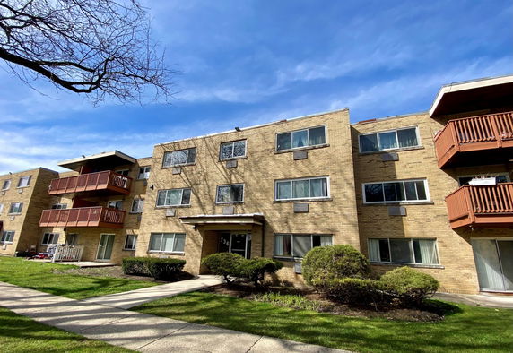 Front view of a three-story apartment building with balconies.