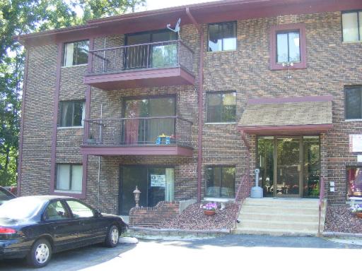 Front view of a multi-story brick apartment building with balconies.