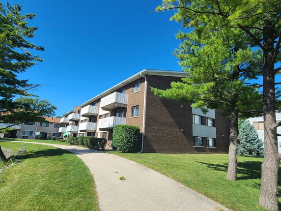 Front view of a multi-story apartment building with balconies.