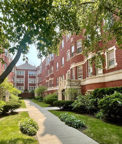 Front view of a multi-story brick building with decorative stone elements.