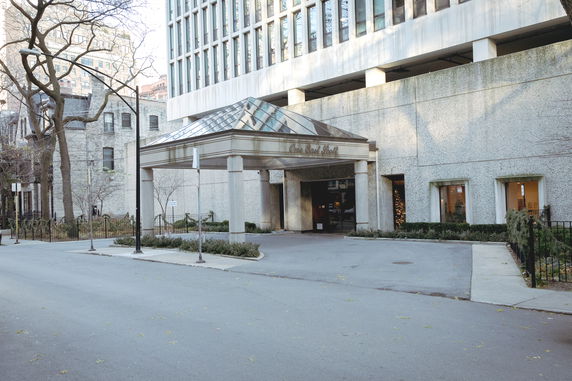 Front view of a building with a glass-canopied entrance.