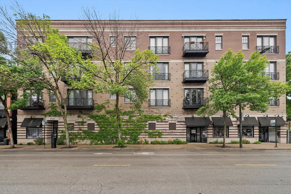 Front view of a multi-story brick building with balconies.