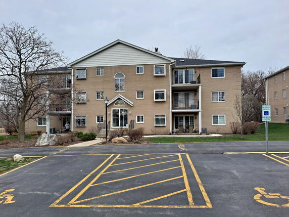 Front view of a multi-story apartment building with balconies.