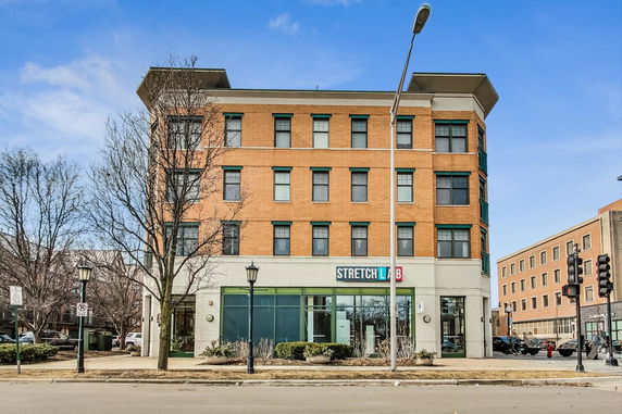 Front view of a multi-story brick building with commercial space on the ground floor.