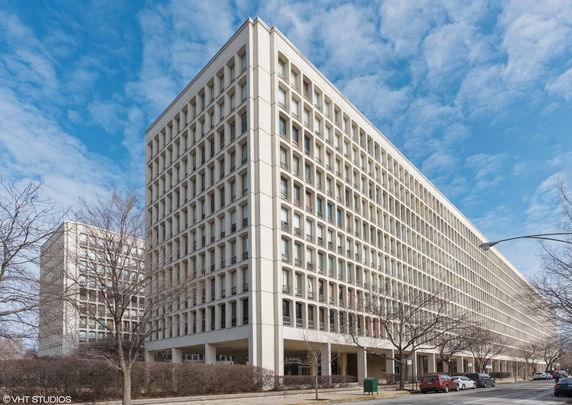 Front view of a large, multi-story building with a grid-like window pattern.