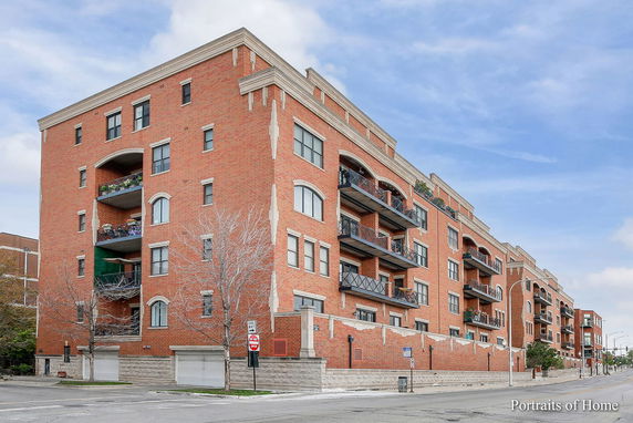 Front view of a multi-story brick apartment building with balconies.