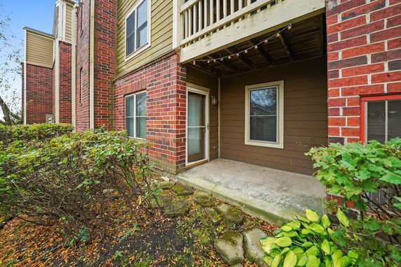 Front view of a building with brick and wooden siding and a small porch.
