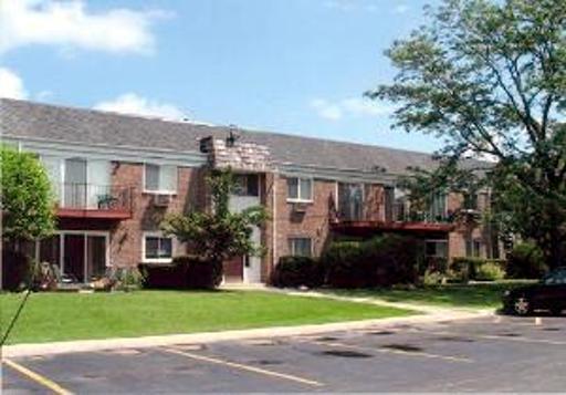 Front view of a two-story brick apartment building with balconies.