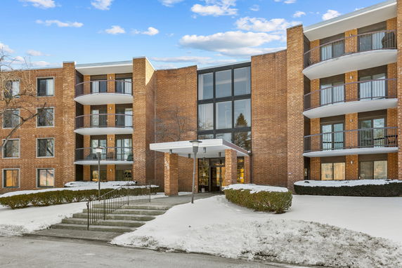 Front view of a multi-story brick building with balconies.