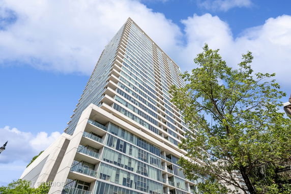 Front view of a tall modern high-rise building with many windows and balconies.