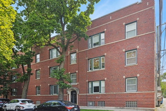 Front view of a multi-story brick apartment building.