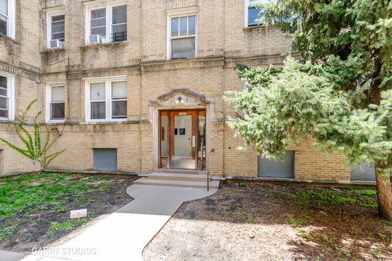 Front view of a multi-story brick building with a central entrance.