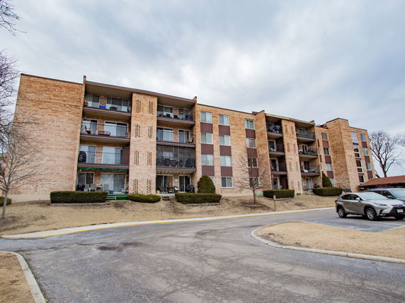 Front view of a multi-story apartment building with balconies.