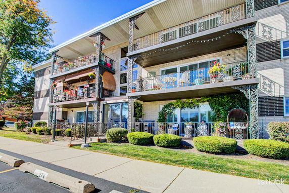 Front view of a multi-story building with balconies and decorative railings.