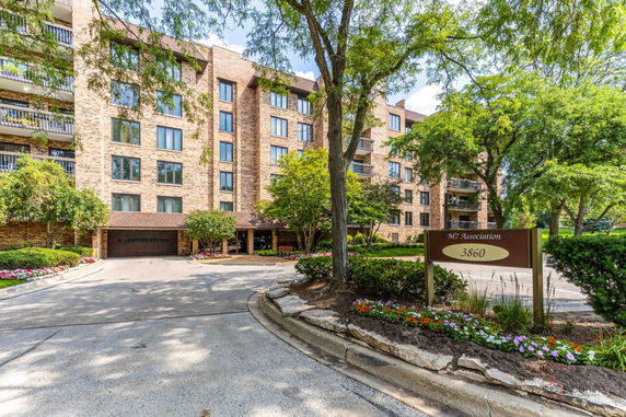 Front view of a multi-story brick apartment building with balconies.