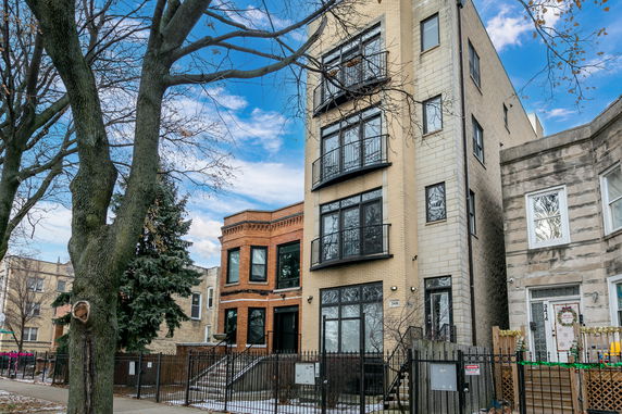 Front view of a multi-story residential building with brick and stone facade.