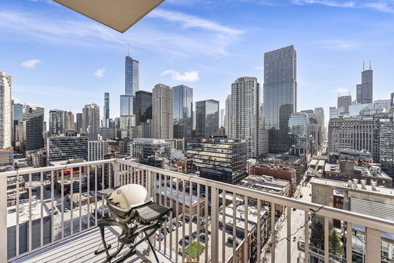 Panoramic view of a cityscape from a balcony with high-rise buildings.