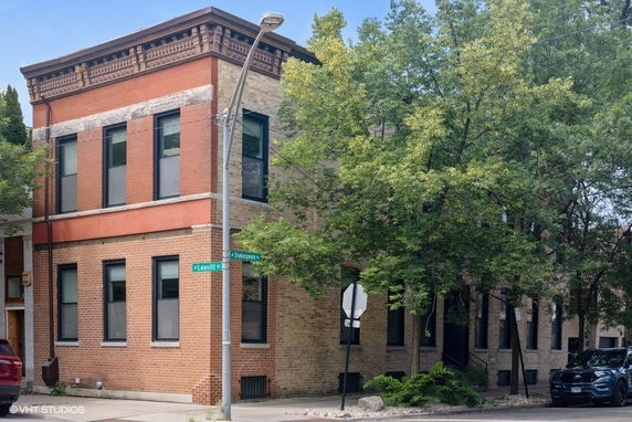 Front view of a two-story brick building at a street corner.