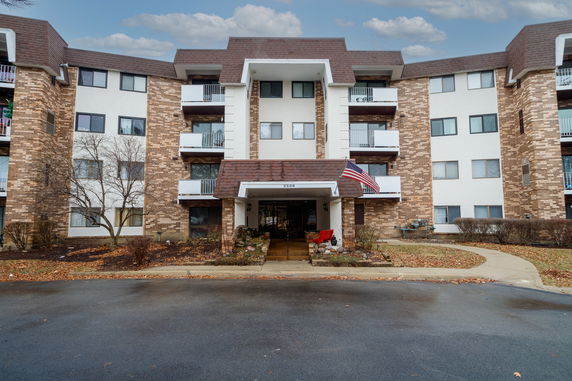 Front view of a multi-story building with a central entrance and balconies.