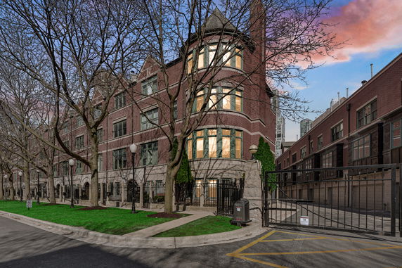 Front view of a multi-story brick building with large windows and a rounded corner section.