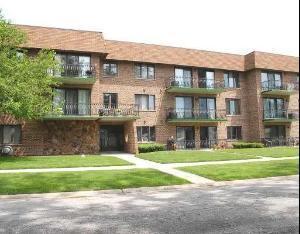Front view of a three-story apartment building with balconies.