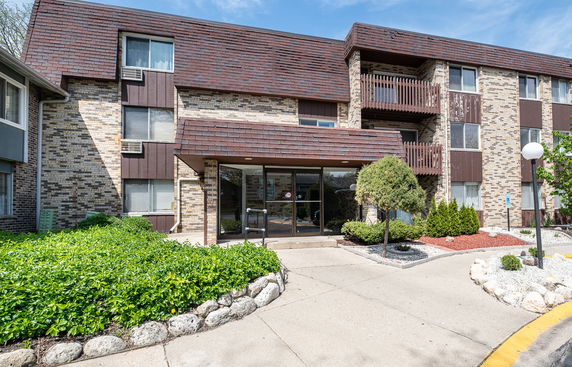 Front view of a multi-story residential building with a brick exterior and balconies.