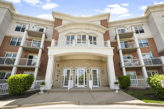 Front view of a multi-story brick and stucco building with balconies.
