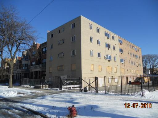 Front view of a multi-story building with boarded windows.