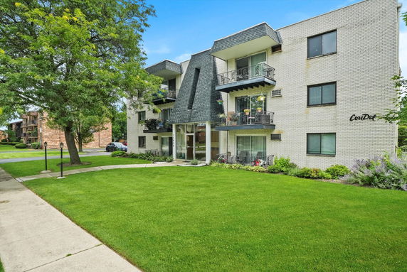 Front view of a three-story apartment building with balconies.