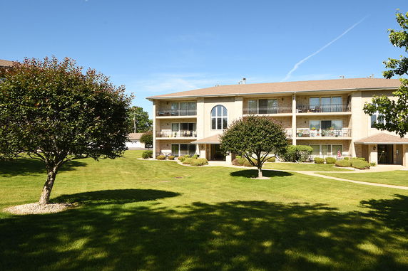 Front view of a multi-story apartment building with balconies.