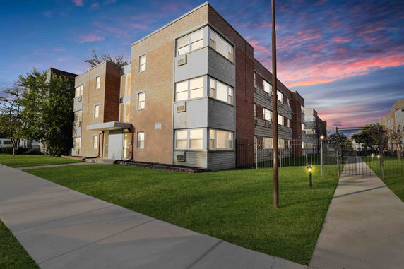 Front view of a multi-story brick apartment building.