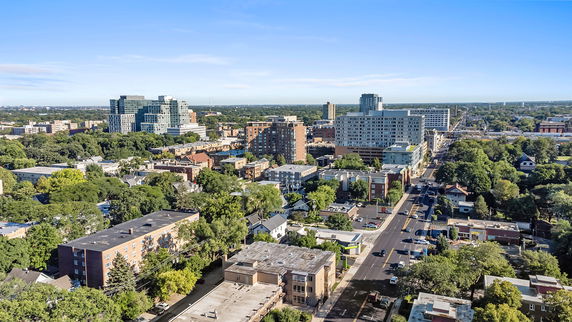 Panoramic view of urban area with multiple buildings and green spaces.